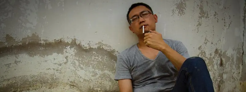 A smoker looking stressed despite smoking, highlighting the myth of nicotine as stress relief.
