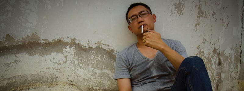 A smoker looking stressed despite smoking, highlighting the myth of nicotine as stress relief.